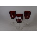 THREE RUBY COLOURED WINE GLASSES