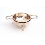 Elizabeth II silver tea strainer and stand, the circular pierced bowl sits between twin angular