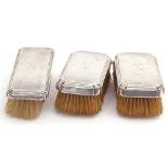 Group of three silver backed brushes, rectangular form, each engraved with a personalised