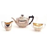 Silver three-piece bachelor's tea service of oval form comprising tea pot, twin handled sugar bowl