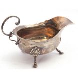 Edward VII silver sauce boat of typical form with card cut rim and applied flying C-scroll handle,