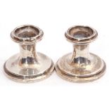 Pair of George V silver dwarf candlesticks of circular shape on stepped spreading loaded bases,