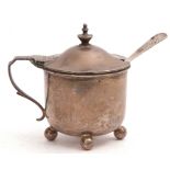 Victorian silver mustard of circular form, hinged lid with urn finial and angular handle, raised