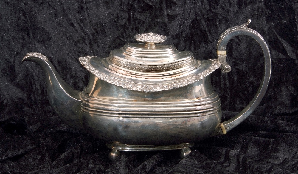 George IV silver tea pot of oval form having a reeded body with applied scroll and shell rim, a