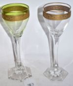 Pair of wine glasses, probably Moser, with green tint and a gilt engraved band above a faceted