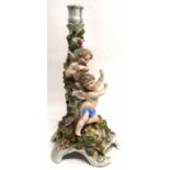 Continental porcelain candlestick, the main decoration with trailing flowers and two cherubs, 33cm