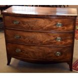 Late Georgian mahogany bow front chest of three drawers with oval embossed brass fittings and raised