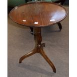 19th century mahogany wine table of circular form with raised edge, the tip-top raised on a turned