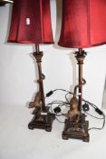 PAIR OF METAL TABLE LAMPS, THE BASES WITH MODELS OF MONKEYS WITH RED SHADES