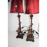 PAIR OF METAL TABLE LAMPS, THE BASES WITH MODELS OF MONKEYS WITH RED SHADES