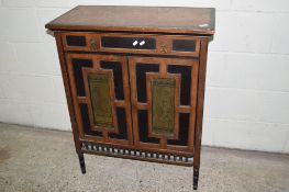 ORIENTAL STYLE SIDE CABINET WITH HEAVILY PANELLED DECORATION AND INSET WITH TWO PICTORIAL BRASS