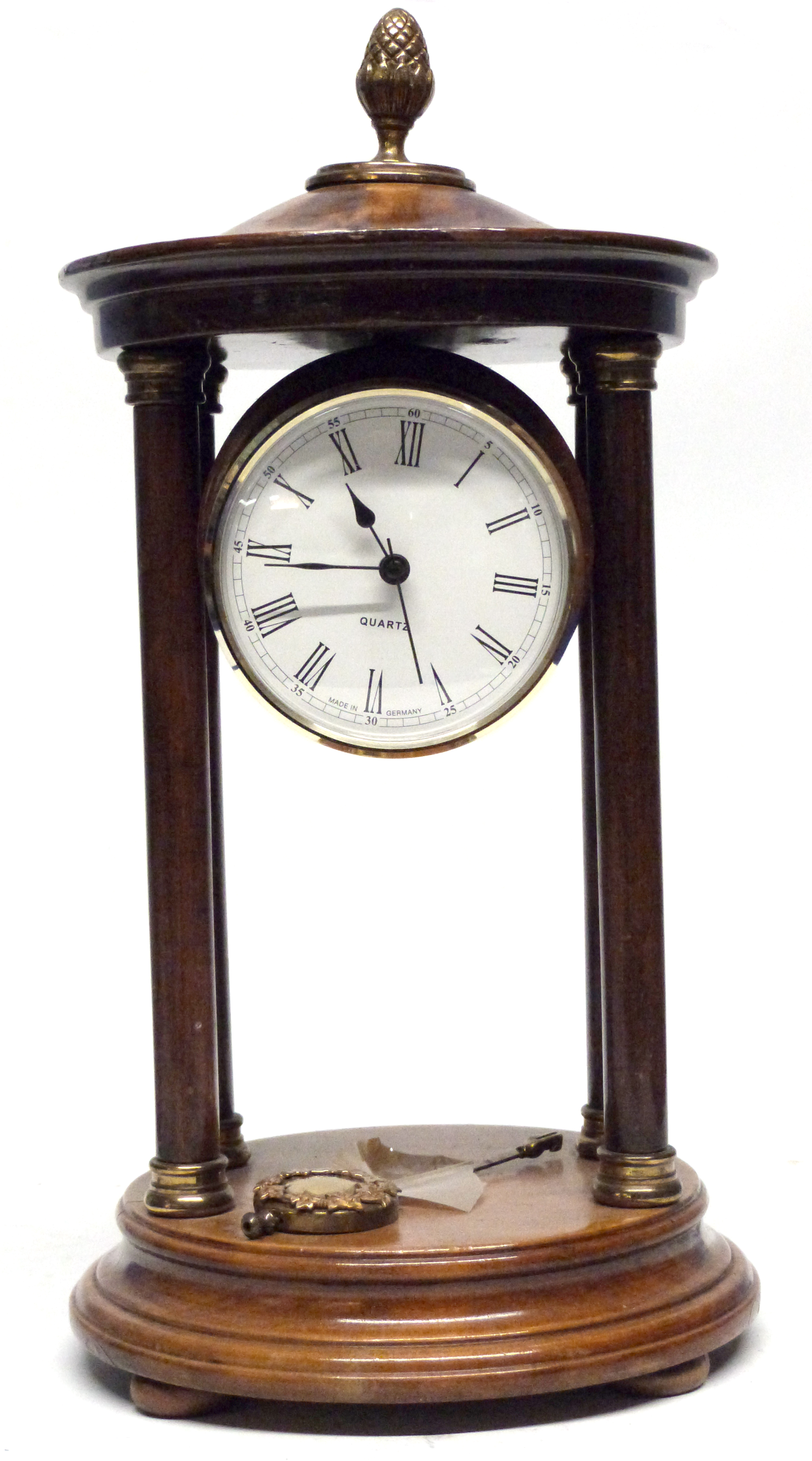 Quartz clock in wooden case, supported by four wooden pillars, with brass acorn knop, 27cm high