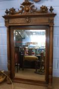Late Victorian carved walnut framed wall mirror having double cornucopia and shield embellishments