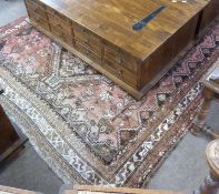 Caucasian wool carpet with three large lozenges to centre, in faded beige, red and pink, 173 x