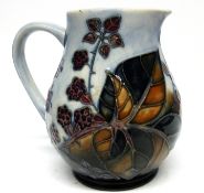 Moorcroft jug with a tube lined design of flowers and berries, 16cm high