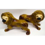 Two large pottery models of lions, 35cm long