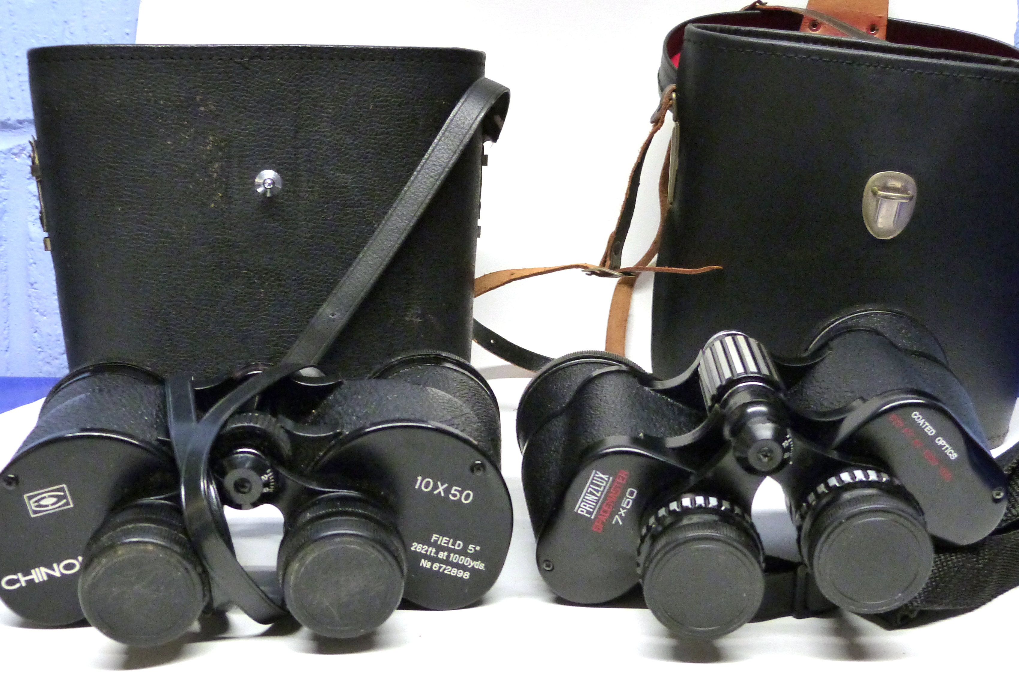 Two binoculars in cases, one manufactured by Chinon 10x50, the other by Prinzlux Spacemaster 7x50 (