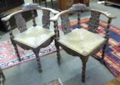 Pair of late 19th/early 20th century carved oak corner chairs with curved backs, barley twist