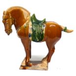 Replica of a Chinese Tang period horse in typical colours of brown and green on rectangular base,