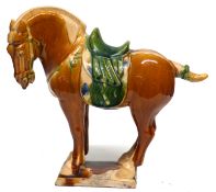Replica of a Chinese Tang period horse in typical colours of brown and green on rectangular base,
