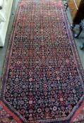 Persian village rug with all over geometric and floret designs in red, blue and beige, 312cm x