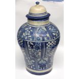 Middle Eastern jar and cover decorated with a blue and white design of flowers, the cover with