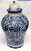 Middle Eastern jar and cover decorated with a blue and white design of flowers, the cover with