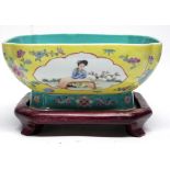 Chinese porcelain yellow ground dish decorated with panels of Chinese figures, the dish on a