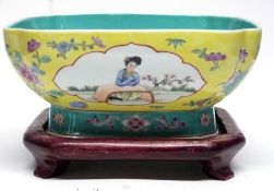 Chinese porcelain yellow ground dish decorated with panels of Chinese figures, the dish on a