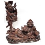 Chinese carved wooden figure of an Immortal, together with a further carved wooden figure on an oval