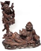 Chinese carved wooden figure of an Immortal, together with a further carved wooden figure on an oval