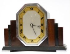 Art Deco mantel clock, in stepped wooden mount supported on metal feet with Roman numeral dial, 17cm