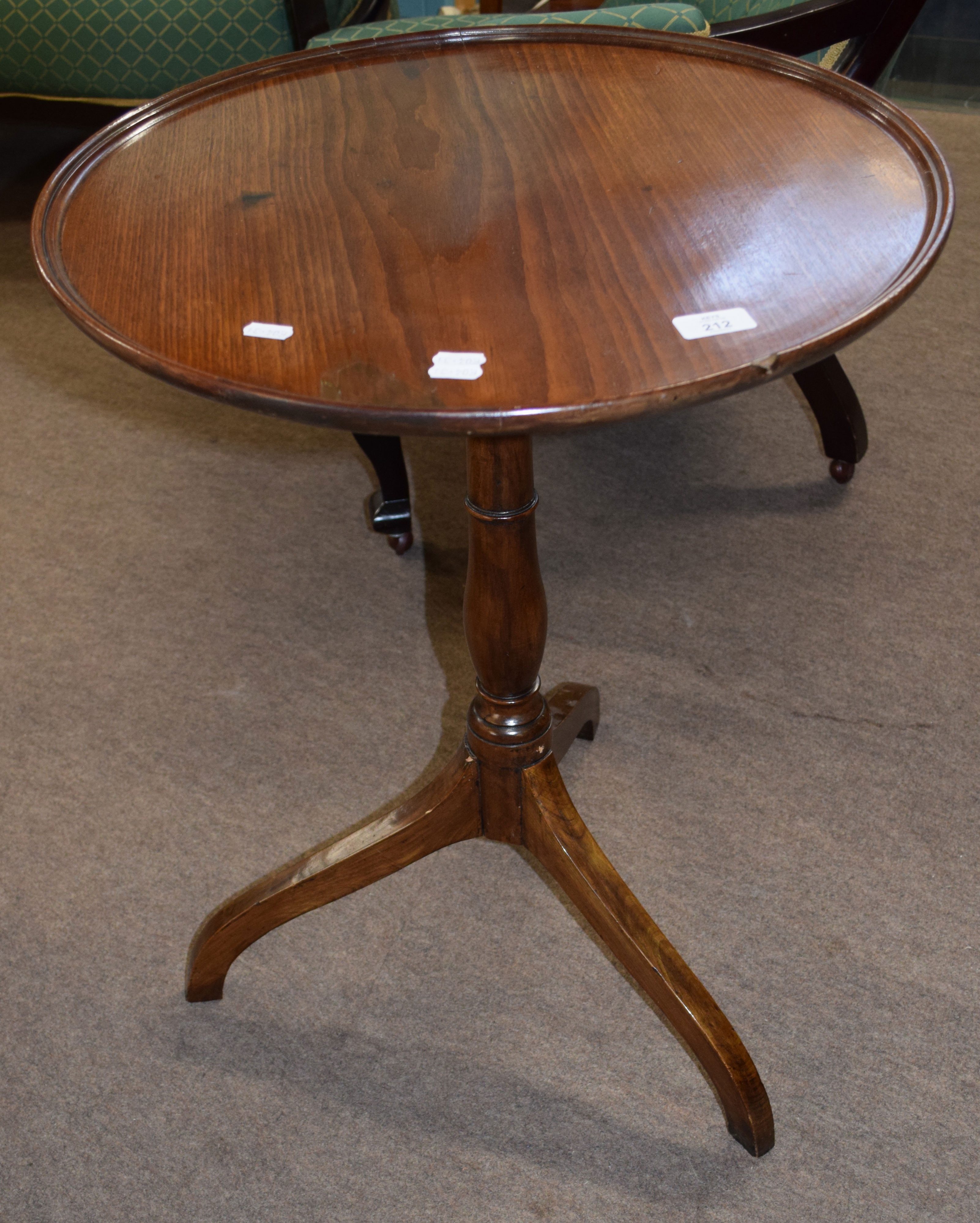 19th century mahogany wine table of circular form with raised edge, the tip-top raised on a turned