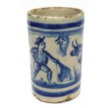 Small cylindrical Continental pottery vase modelled with a bullfighting scene in underglaze blue,