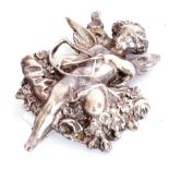 Vintage white cast metal brooch depicting Cupid and his bow and arrow resting on a garland of