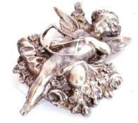 Vintage white cast metal brooch depicting Cupid and his bow and arrow resting on a garland of