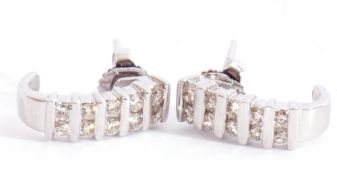 Pair of precious metal diamond half hoop earrings, each with five pairs of small brilliant cut