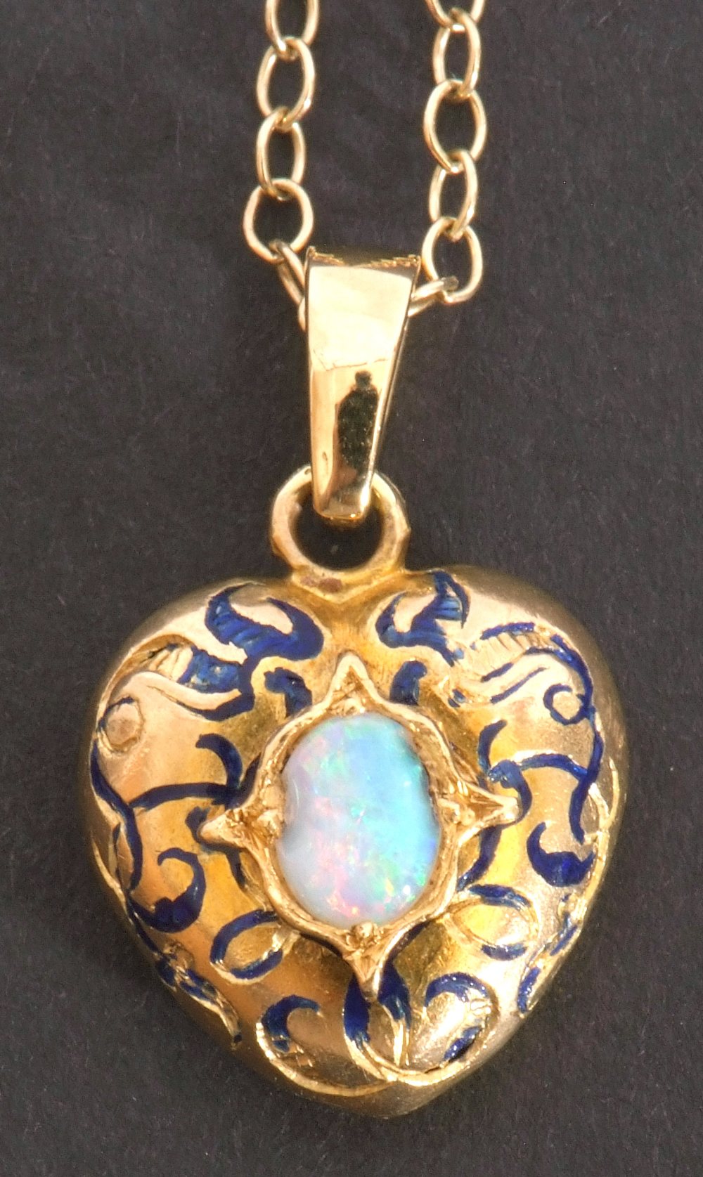 Yellow metal, opal and blue enamel pendant, heart shaped centring an oval opal in an engraved
