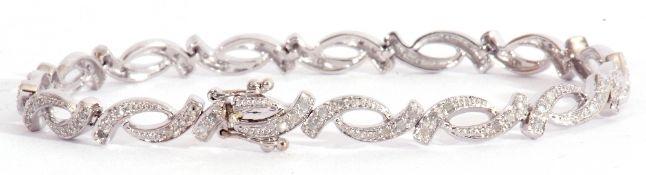 Modern small diamond set bracelet, an oval link design, each with three small graduated diamonds,