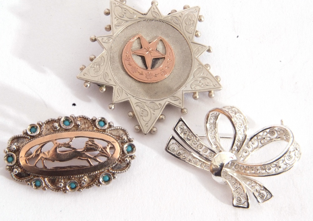 Mixed Lot: three white metal brooches to include a tied ribbon, an oval pierced example with a