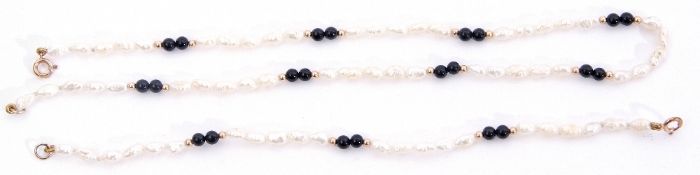 Matching necklace and bracelet of white freshwater cultured pearls interspersed by pairs of black