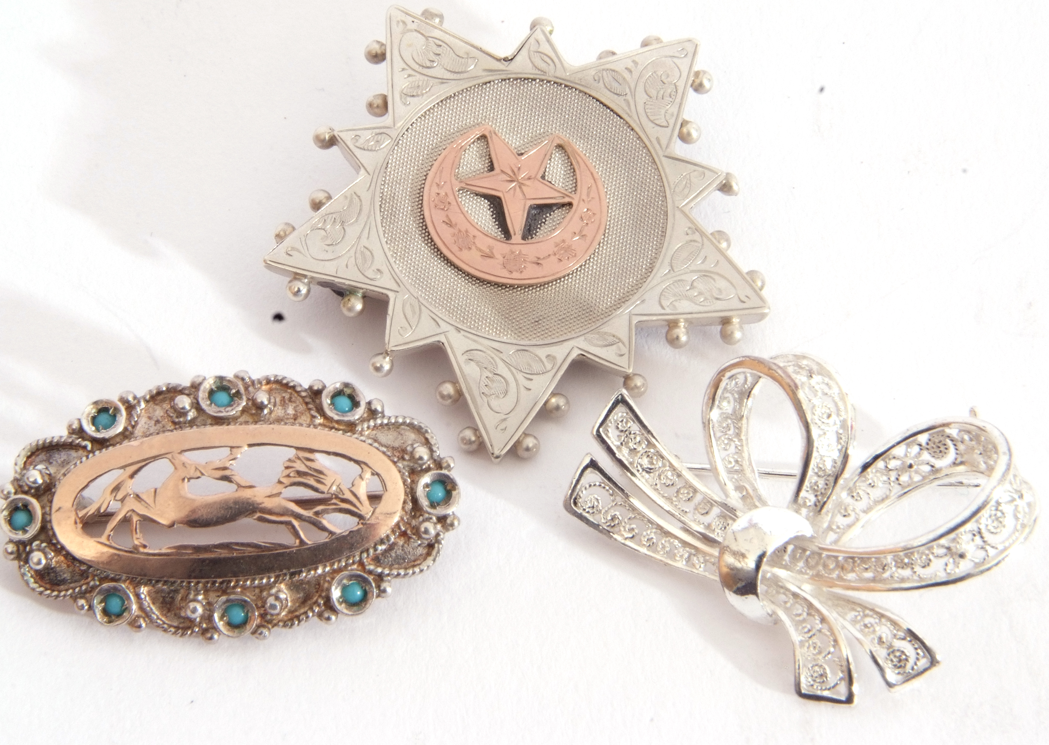 Mixed Lot: three white metal brooches to include a tied ribbon, an oval pierced example with a - Image 2 of 3