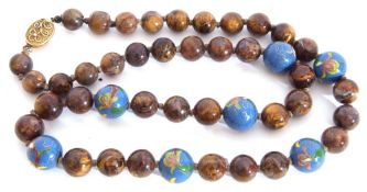 Oriental single row bead necklace, a design featuring mottled brown coloured beads interspersed with