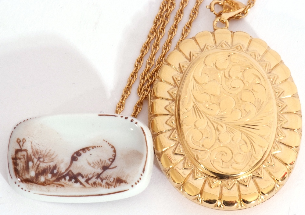 Large gold plated oval locket on a 925 stamped chain together with a porcelain brooch, brass cross