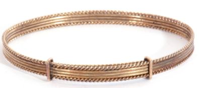 9ct gold expandable bangle, oval shaped with a reeded frame with rope twist border, Birmingham 1987,