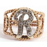 Modern yellow metal and diamond letter "R" ring, centring a letter R set with small single cut