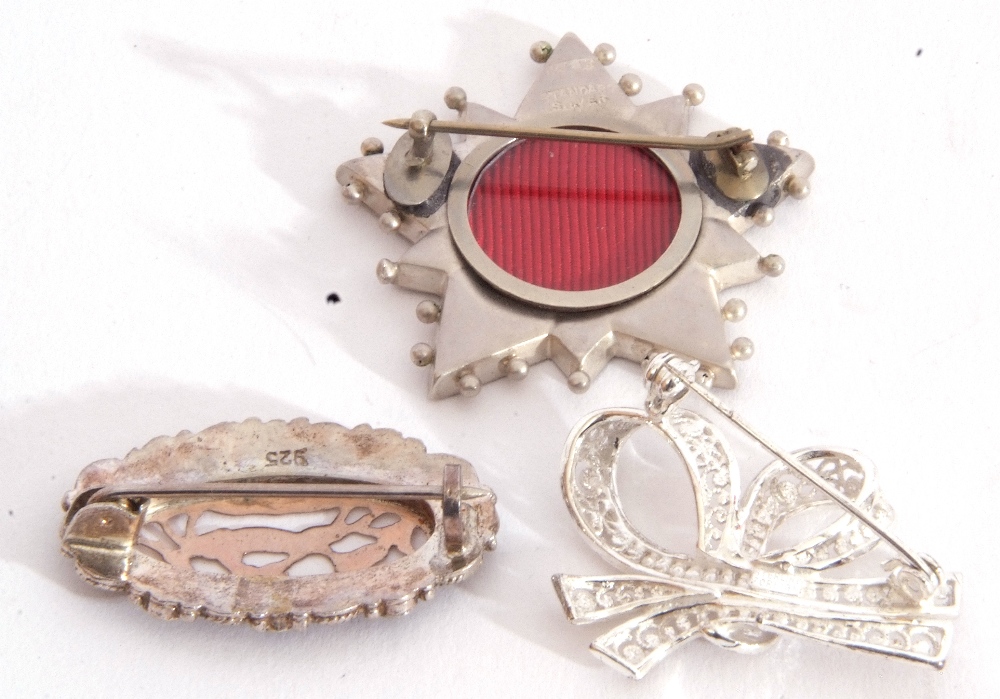 Mixed Lot: three white metal brooches to include a tied ribbon, an oval pierced example with a - Image 3 of 3