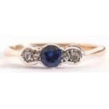 Sapphire and diamond three stone ring centring a small round cut sapphire flanked by small old cut