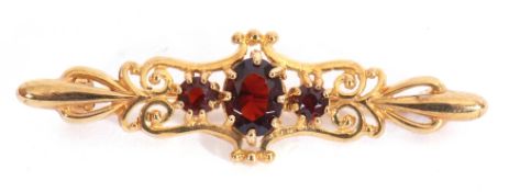 9ct gold and three stone garnet brooch, the graduated oval and round cut garnets in an open work