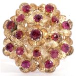 Yellow metal and ruby set cocktail ring of domed shape, with 17 small round cut garnets, each raised